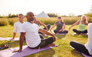 Image of man doing yoga with others and being active while living with prostate cancer