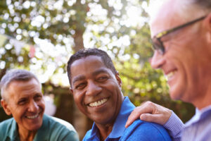Image of three men laughing together demonstrating living with prostate cancer.